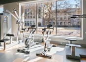 Thumbnail 19 of 34 - Fitness center with large window view of nearby buildings