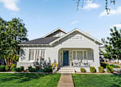 Thumbnail 3 of 6 - A white house with a blue door and a small porch.