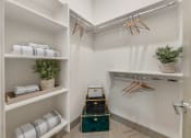 Thumbnail 12 of 35 - a walk in closet with folded towels and a luggage cart