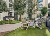 Thumbnail 17 of 35 - a patio with a table and chairs in front of an apartment building