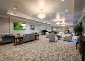 Thumbnail 26 of 34 - Social room with seating and carpet flooring