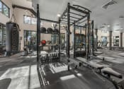 Thumbnail 25 of 35 - a gym with weights and other equipment in a building with windows
