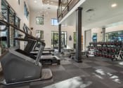Thumbnail 27 of 35 - a gym with treadmills and weights in a building with windows