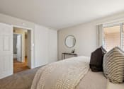 Thumbnail 44 of 46 - A bedroom with a large bed and a round mirror on the wall.