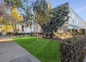 Thumbnail 38 of 46 - A building with a green lawn in front of it.