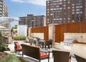 Thumbnail 19 of 38 - a rendering of a rooftop patio with a grill and dining area