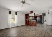 Thumbnail 30 of 39 - an empty kitchen and living room with a ceiling fan