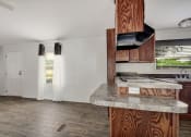 Thumbnail 29 of 39 - a kitchen and living room with white walls and wood floors