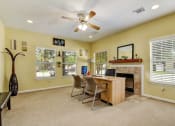 Thumbnail 3 of 39 - a home office with a fireplace and a ceiling fan