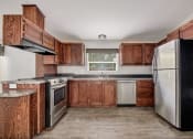 Thumbnail 25 of 39 - a kitchen with wooden cabinets and stainless steel appliances