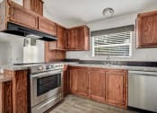 Thumbnail 24 of 39 - a kitchen with wooden cabinets and stainless steel appliances