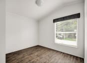 Thumbnail 21 of 39 - an empty room with a window and wooden floors