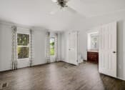 Thumbnail 16 of 39 - a living room with a ceiling fan and two windows