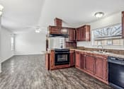 Thumbnail 17 of 22 - A kitchen with a black oven and wooden cabinets.