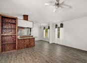 Thumbnail 8 of 30 - Living room and kitchen with wooden cabinet at Country Oaks, San Antonio, Texas