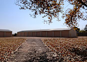 Thumbnail 17 of 46 - a building with a gravel road in front of it and a tree at Circle Park, Wyoming