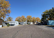 Thumbnail 22 of 46 - an empty street in a mobile home park with trees at Circle Park, Wyoming, 82007