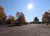 Thumbnail 26 of 46 - a row of mobile homes in a parking lot with the sun shining over them at Circle Park, Cheyenne, Wyoming