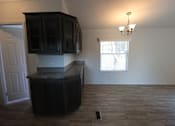 Thumbnail 44 of 46 - an empty kitchen with dark cabinets and a window at Circle Park, Cheyenne