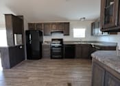 Thumbnail 38 of 46 - a kitchen with wooden cabinets and a black stove and refrigerator at Circle Park, Cheyenne