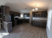 Thumbnail 29 of 46 - an empty kitchen with black appliances and wooden cabinets at Circle Park, Wyoming