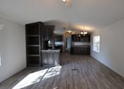 Thumbnail 41 of 46 - an empty living room with wooden floors and a kitchen at Circle Park, Wyoming, 82007