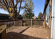 Thumbnail 24 of 46 - a backyard deck with a tree and a blue sky at Circle Park, Cheyenne, WY