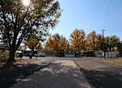 Thumbnail 20 of 46 - a parking lot with houses and trees on a sunny day at Circle Park, Cheyenne, Wyoming