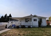 Thumbnail 9 of 22 - a white house with a porch and a lawn at Country Lane, Cheyenne, 82007