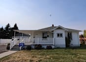 Thumbnail 13 of 22 - a white house with a porch and a bird flying over it at Country Lane, Cheyenne