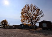 Thumbnail 8 of 22 - a row of small houses in a parking lot with a tree at Country Lane, Cheyenne, Wyoming