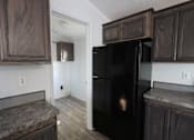 Thumbnail 10 of 20 - a kitchen with a black refrigerator and wooden cabinets at Up House, Connecticut