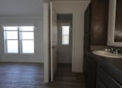 Thumbnail 9 of 20 - an empty bathroom with a sink and a door to a hallway at Horizon MHC, Rock Springs, WY