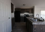 Thumbnail 14 of 20 - a kitchen with wooden cabinets and a sink at Horizon MHC, Wyoming