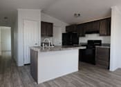 Thumbnail 8 of 20 - an empty kitchen with an island in the middle of it at Horizon MHC, Wyoming