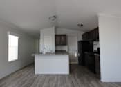 Thumbnail 13 of 20 - an empty kitchen with a white counter top and a black refrigerator at Horizon MHC, Rock Springs, Wyoming