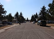 Thumbnail 5 of 9 - a street with cars parked on the side of it and trees at Kimberly Village, Cheyenne, Wyoming