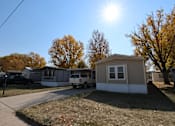 Thumbnail 4 of 7 - a row of mobile homes on a street with the sun shining over them at Mobile Home Village, Cheyenne, Wyoming