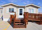 Thumbnail 5 of 19 - a yellow tiny house with a wooden deck in front of it at Pioneer Park, Green River