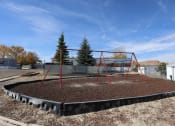 Thumbnail 6 of 19 - a playground with a swing set and some dirt at Pioneer Park, Green River, 82935