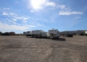 Thumbnail 15 of 19 - a row of travel trailers parked in a dirt lot under a blue sky at Pioneer Park, Green River, Wyoming
