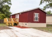 Thumbnail 9 of 13 - red mobile home exterior with large driveway at Maple Grove, Nebraska