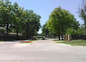 Thumbnail 3 of 13 - A street with a sidewalk and a fence.