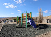 Thumbnail 3 of 5 - A playground with a purple slide and green and yellow play structure.