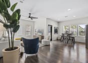 Thumbnail 5 of 50 - a living room with white walls and a large potted plant