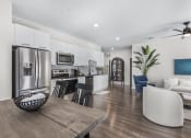 Thumbnail 3 of 50 - a kitchen and living room with stainless steel appliances and a table