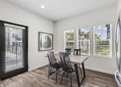 Thumbnail 8 of 50 - a dining room with a table and chairs and a door to a balcony
