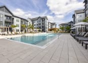 Thumbnail 28 of 50 - a swimming pool in front of a row of apartment buildings