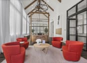 Thumbnail 39 of 50 - a living room with red chairs and a table