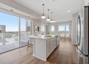 Thumbnail 13 of 57 - an open kitchen and dining area with a balcony